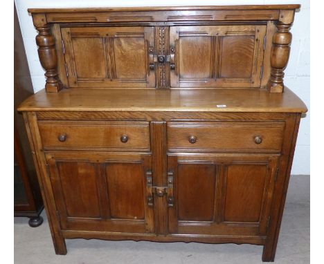A Jacobean style light oak buffet sideboard with double cupboard over 2 drawers and 2 cupboards