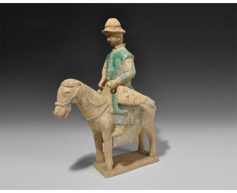 20th century AD. A ceramic figurine of a mounted archer on a rectangular base, with green-glazed coat, blue-glazed garments a