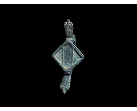 2nd century AD. A bronze plate brooch with central lozengiform plaque and beast-head finials above and below; the plaque with