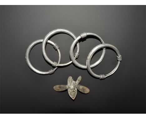 20th century AD. A mixed group comprising: four hollow-section bronze bangles, each with the tapered ends coiled over the loo