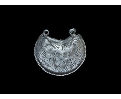 11th-12th century AD. A hollow silver crescentic pendant with beaded border and four suspension loops, reserved design to eac