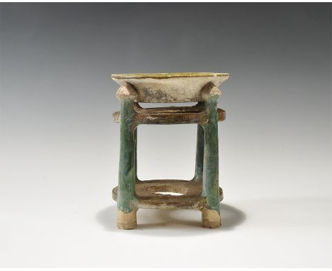 Ming Dynasty, 1368-1644 AD. A broad ceramic dish with flared rim, upper face glazed olive green, separate stand with two oliv