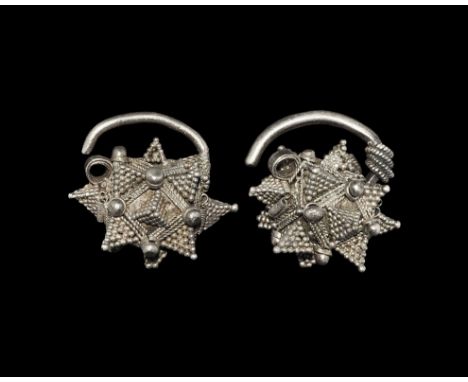 8th-10th century AD. A matched pair of earrings each with round-section shank, polyhedral body with multiple strands of ropew