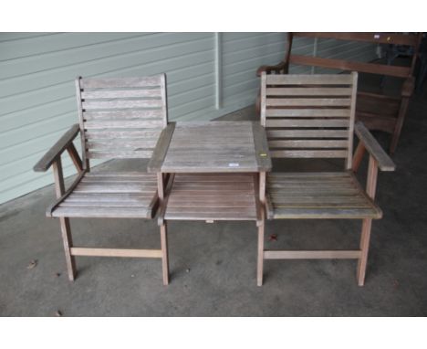 A teak garden bench with integral table