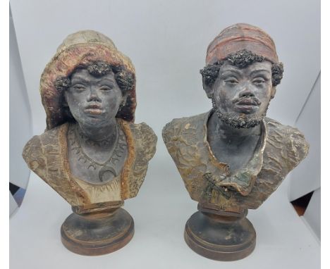 A pair of Goldscheider cold painted terracotta portrait busts of an Arab man and woman on stepped circular socles, impressed 