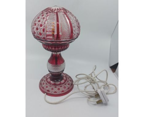 A ruby cut glass table lamp with baluster column and mushroom shaped shade, wired for electricity, 32cm high