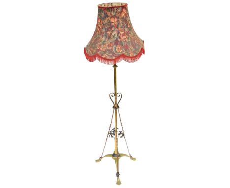 An early 20thC brass standard lamp, with floral decoration, with shade, 173cm high. 