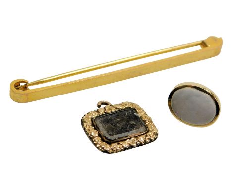 A 9ct gold pin, 2.0g, 9ct gold and mother of pearl tie pin, 0.9, and a Victorian hair locket pendant, set in yellow metal. (3