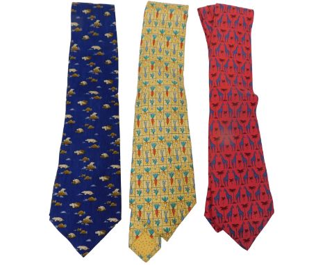 Three Hermes silk ties, comprising a red tie with giraffes, a yellow tie with root vegetables, and a dark blue tie with moles