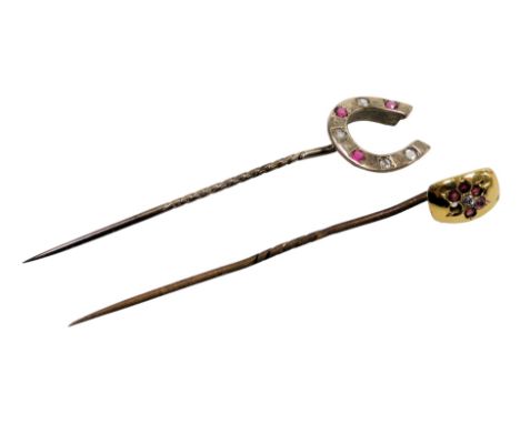 A Victorian ruby and diamond stick pin, in a horseshoe design, one ruby lacking, in yellow metal, and a further pin, set with