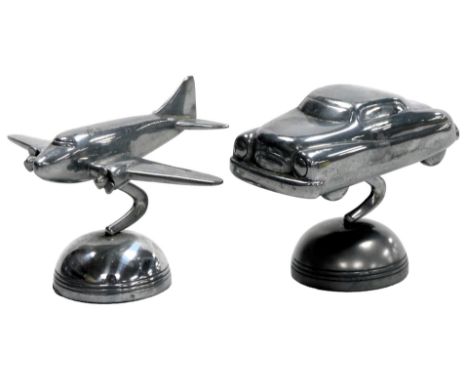 A pewter desk stand, modelled as a motor car, and another modelled as a passenger airplane, engraved to base Fossil.