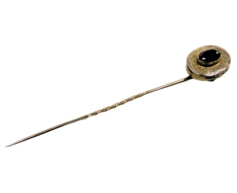 A Victorian amethyst tie pin, set in an oval locket frame, with engraved decoration, yellow metal, 3.3g. 