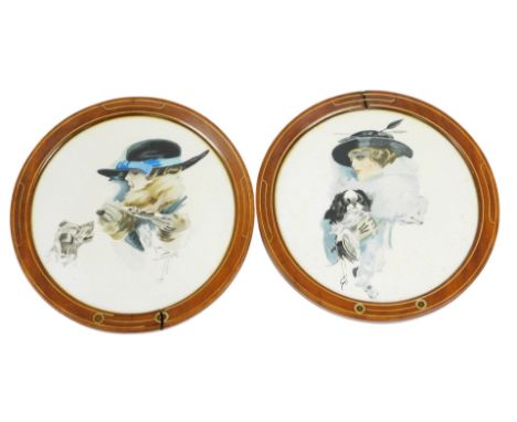 A pair of early 20thC prints, of Gibson type girls, each with a dog, within inlaid circular wooden frames, 36cm wide.