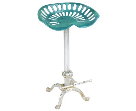 A vintage cast iron tractor seat stool, the green painted seat raised on a grey column above four cabriole legs, 84cm high. 
