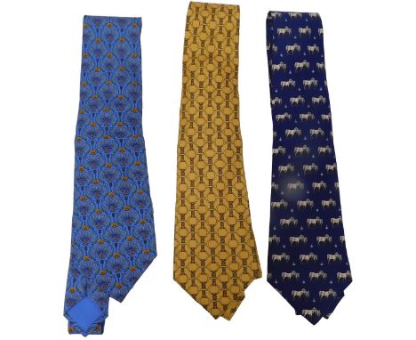 Three Hermes silk ties, comprising a pale blue tie with dolphins and Acanthus leaves, a gold tie with belt and snaffles, and 
