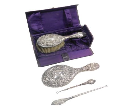 A George V silver backed hand mirror and hair brush, with embossed floral decoration, Birmingham 1913 and Chester 1904, cased