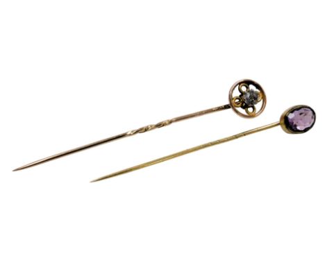 An amethyst set tie pin, in yellow metal, and a further tie pin, set with an aquamarine, in a wheel shaped design, yellow met