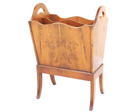 A Reprodux yew wood magazine trough, of twin division form, raised on outswept legs, 58cm high, 39cm wide, 25cm deep.