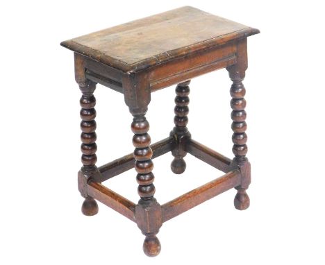 An 18thC oak stool, raised on bobbin turned legs united by a box stretcher, 58cm high, 47cm wide. 
