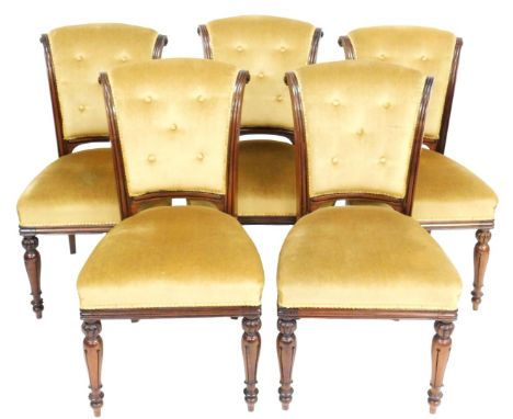A set of five late Regency mahogany scroll back dining chairs, upholstered in button back gold draylon, raised on turned and 
