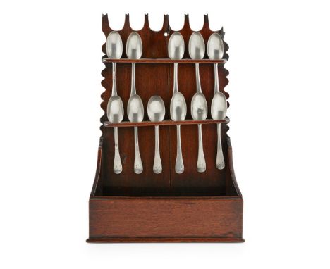 GEORGIAN OAK SPOON RACK AND PEWTER SPOONS  the carved top with U-form lobes, above the two-tiered rack and splayed base tray,