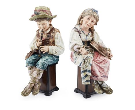 PAIR OF LARGE CONTINENTAL MAJOLICA FIGURES  LATE 19TH/ EARLY 20TH CENTURY   modelled as a boy with a green hat and shoulder b