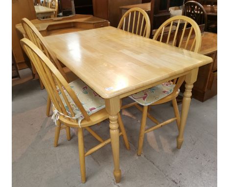 A modern rectangular lightwood dining table and 4 hoop and stick back chairs 