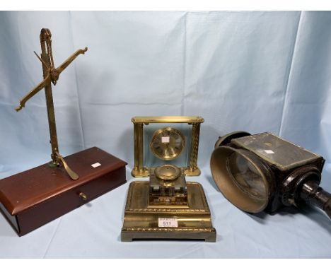 A 19th century heavy glass inkwell on brass stand, a reproduction gilt metal mantle clock, a letter rack, a balance scale and