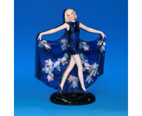 A Lorenzl for Goldscheider figure of a girl in a short blue evening gown with outstretched batwing style floral patten cape, 