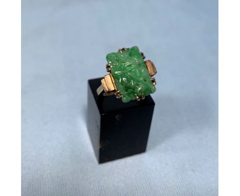 A gold ring stamped 9ct with jade coloured carved rectangular stone 