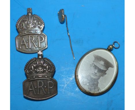 A WWI period photo locket, marked '9CT'; 2 silver ARP badges; a yellow metal bison stick pin