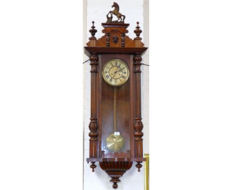 A 19th century walnut Vienna wall clock with horse finial and half turned side pillars, striking spring driven movement