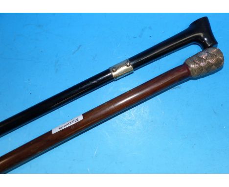 An ebonised walking cane with white metal mount; a stick with woven silver wire knop