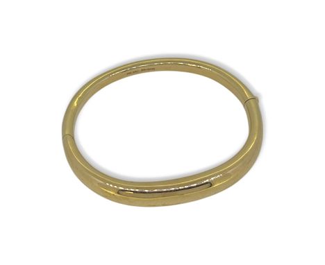 A modern tapered bangle, inside diameter 6cm, width 8.5mm, stamped '750' and tested as 18ct gold, weight 41.4g