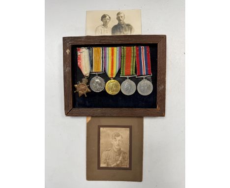 A mounted set of medals together with two photographs, comprising a WWI group of three (1914 star, British War Medal and Vict