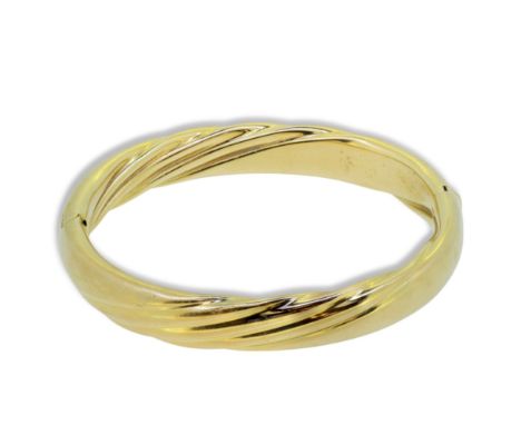 A modern bangle, inside diameter 5.5cm, width 9.7mm, stamped '750' and tested as 18ct gold, weight 27.2g