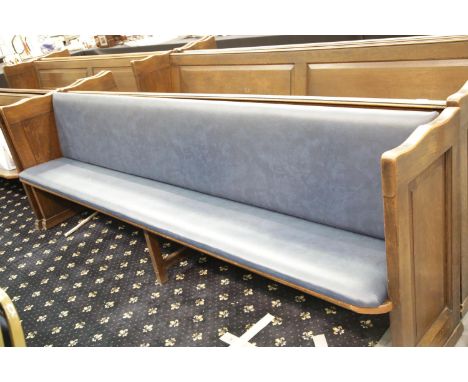 Oak church pew with centre leg and hymnal shelf to back, with upholstered seat and back rest. L: 162 cm. This lot is not avai