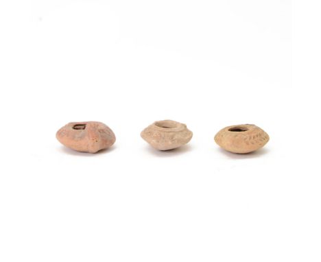 Antiquities; Jewish terracotta oil lamp, with flared decoration and raised fruiting motifs, together with two other oil lamps