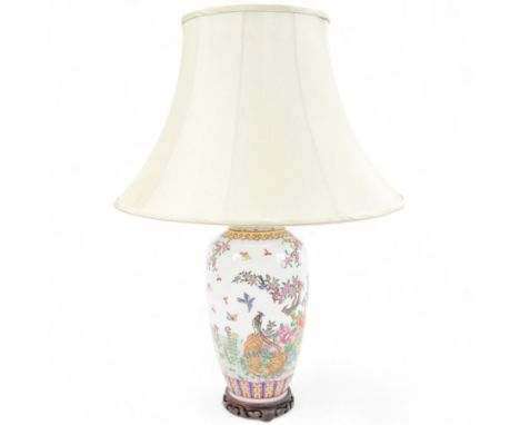 Chinese famille rose table lamp, of baluster form, decorated with birds in blossoming branches, upon a circular wooden base w