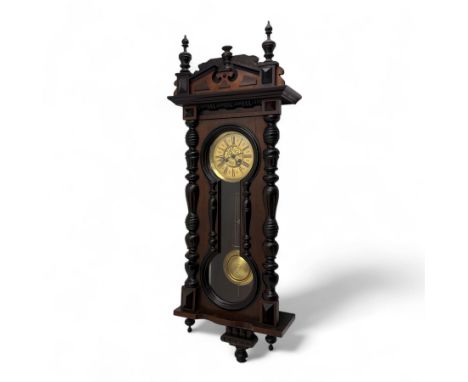 German- 19th century 8-day spring driven wall clock in a mahogany case with turned finials and pendants, architectural pedime