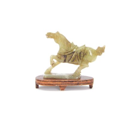 20th century Chinese jade figure of a horse, modelled with its front left leg raised, on a rectangular base, with wooden stan
