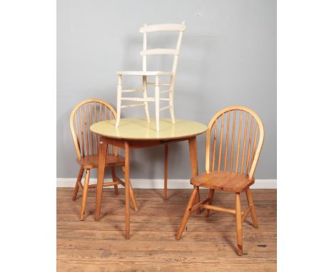 A light oak drop-leaf table with Formica top, together with a pair of 'Goldenpine' chairs and one other painted example.  