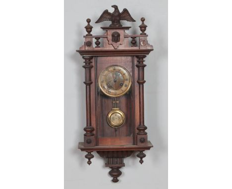 A Victorian mahogany cased wall clock with carved eagle design, circular brass and enamel dial inset roman numerals, brass pe
