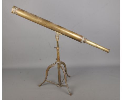 A vintage brass library telescope on brass tripod base.  