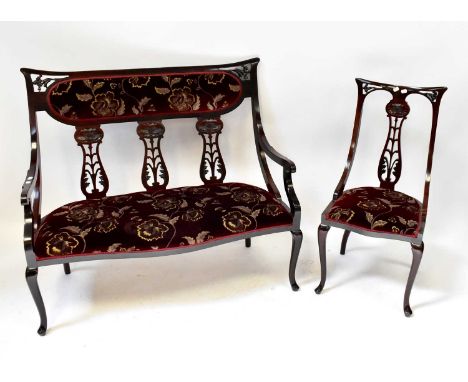 An early 20th century walnut four-piece salon suite comprising a three-seater open arm settee with upholstered seat and back,