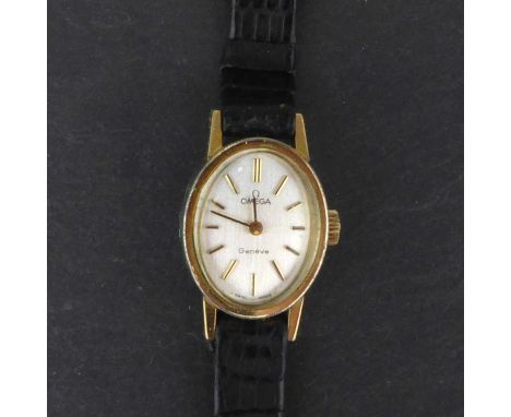 OMEGA; a ladies' vintage gold plated wristwatch, Genéve model, the silvered oval dial set with raised baton numerals, crown w