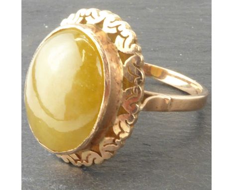 A 9ct rose gold ring with bezel set oval jade cabochon in a floral border, size Q/P, approx. 6.3g.