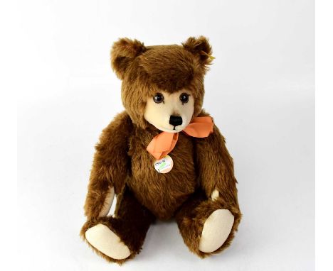 STEIFF: a growler bear in brown with short cream muzzle and peach-coloured ribbon to the neck, cream felt pads, gold button a
