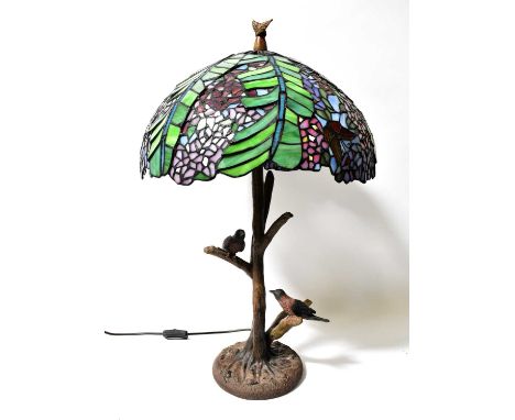 A Tiffany style leaded stained-glass lamp, the shade decorated with wisteria and butterflies on a naturalistic metal base in 