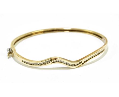 A 9ct gold snap bangle set with clear stones, approx. 10.3g.Condition Report: It is marked 9k to the interior of bangle.